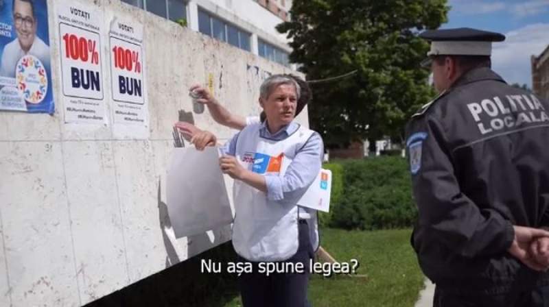 Dacian Cioloș, luat la rost de un polițist local din Alexandria în timp ce lipea un afiș electoral (VIDEO)