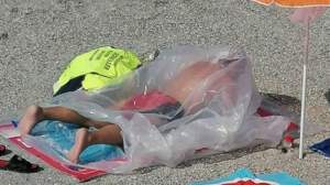 BIZAR! Un bărbat se bronzează într-un sac de plastic pe plaja de la Eforie Nord (VIDEO)