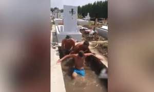 Piscină în cimitir: trei muncitori au umplut cu apă o groapă și au început să se bălăcească (VIDEO)