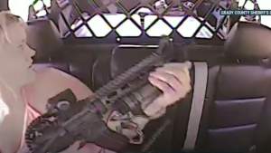 Momentul în care o femeie se eliberează din cătușe și împușcă un ofițer din mașina poliției (VIDEO)